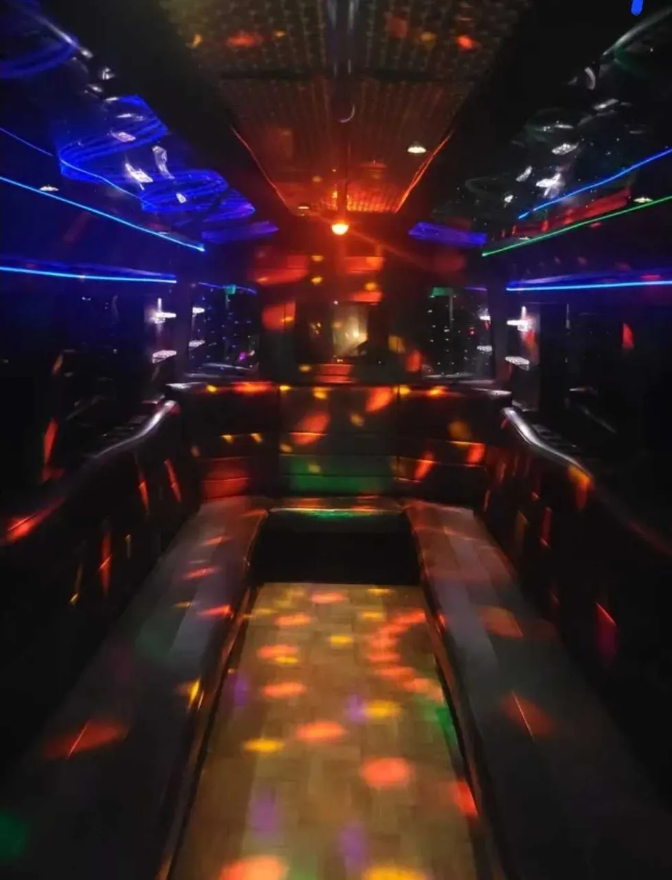 Black Party Bus interior with perimeter lounge seating and LED accent lighting, photo 2 for party bus rental in Schertz, TX