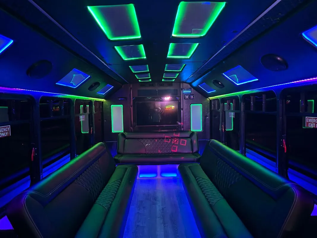 Ford E-450 Series Party Bus interior with perimeter lounge seating, LED accent lighting and LED ceiling lighting for party bus rental in North Attleboro, MA