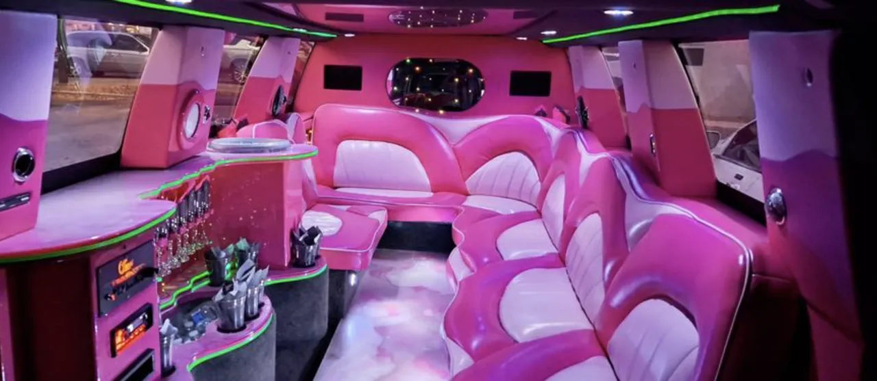 Chevrolet Suburban Limousine interior with sofa-style seating, LED accent lighting and bar area for limo rental in Dillon County, SC