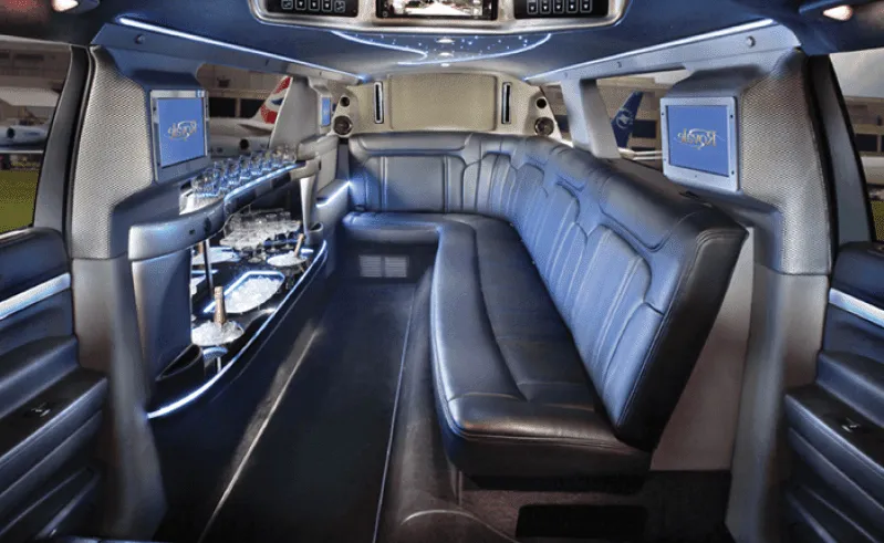 Ford Excursion Limousine interior with sofa-style seating, LED accent lighting and bar area for limo rental