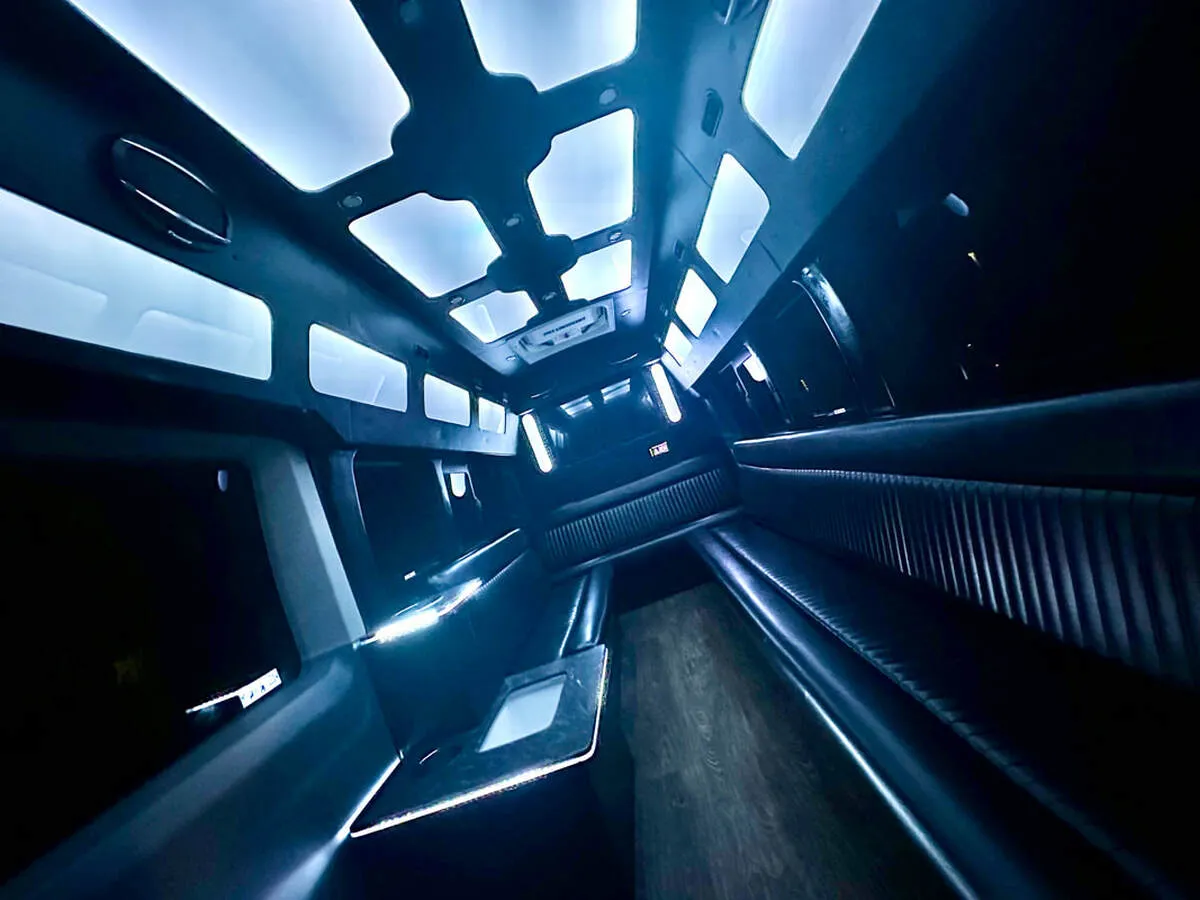 Ford Transit Van interior with perimeter lounge seating, LED accent lighting and LED ceiling lighting for party bus rental