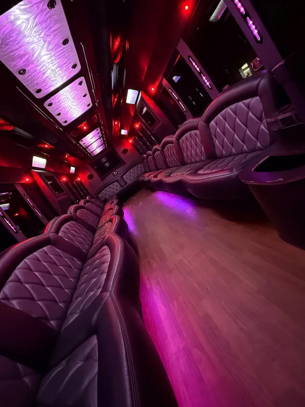 Freightliner Party Bus interior with perimeter lounge seating, LED ceiling lighting and wood-look flooring, photo 11 for party bus rental in North Attleboro, MA