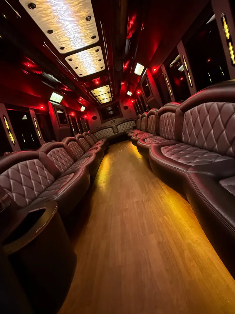 Freightliner Party Bus interior with perimeter lounge seating, LED ceiling lighting and wood-look flooring, photo 12 for party bus rental in North Attleboro, MA