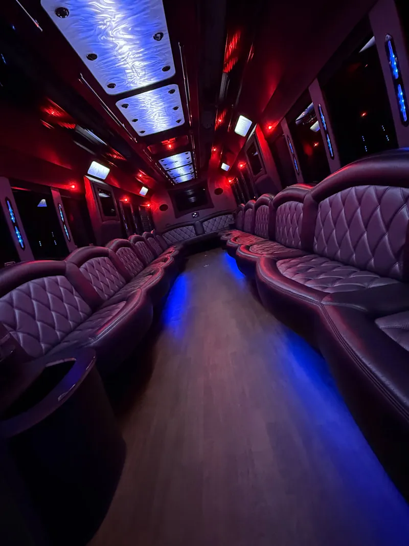 Freightliner Party Bus interior with perimeter lounge seating, LED ceiling lighting and wood-look flooring, photo 8 for party bus rental in North Attleboro, MA