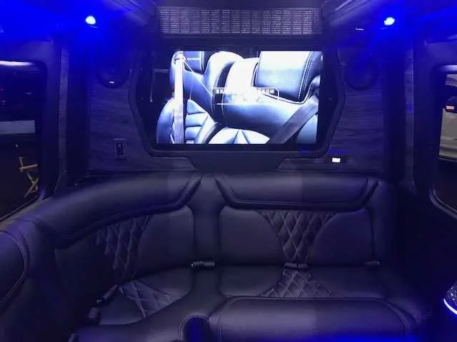Mercedes Party Bus interior with sofa-style seating, LED accent lighting and TV screens for party bus rental in Birds Landing, CA