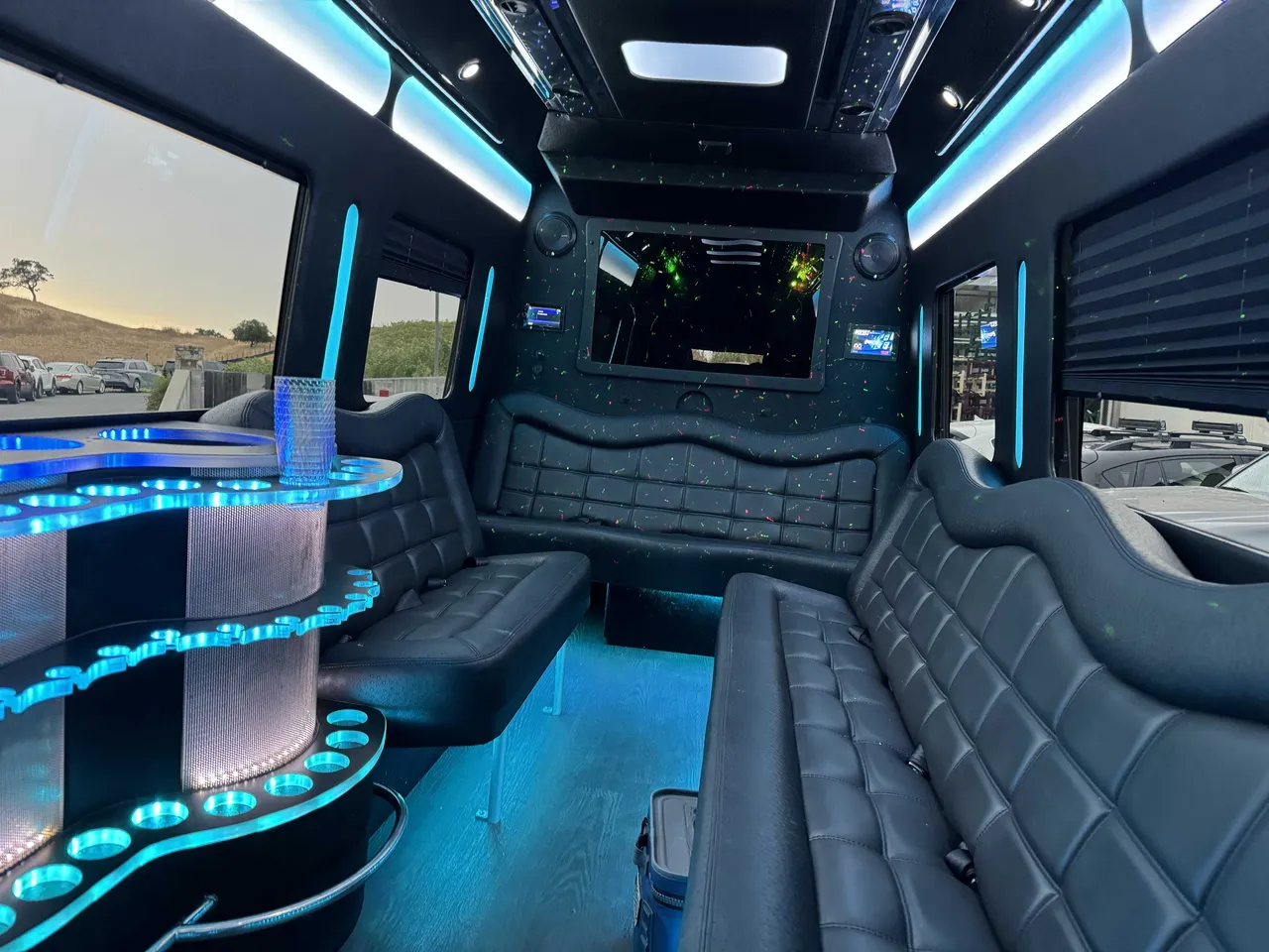 Mercedes Party Bus interior with perimeter lounge seating, window shades and LED accent lighting for party bus rental in Birds Landing, CA
