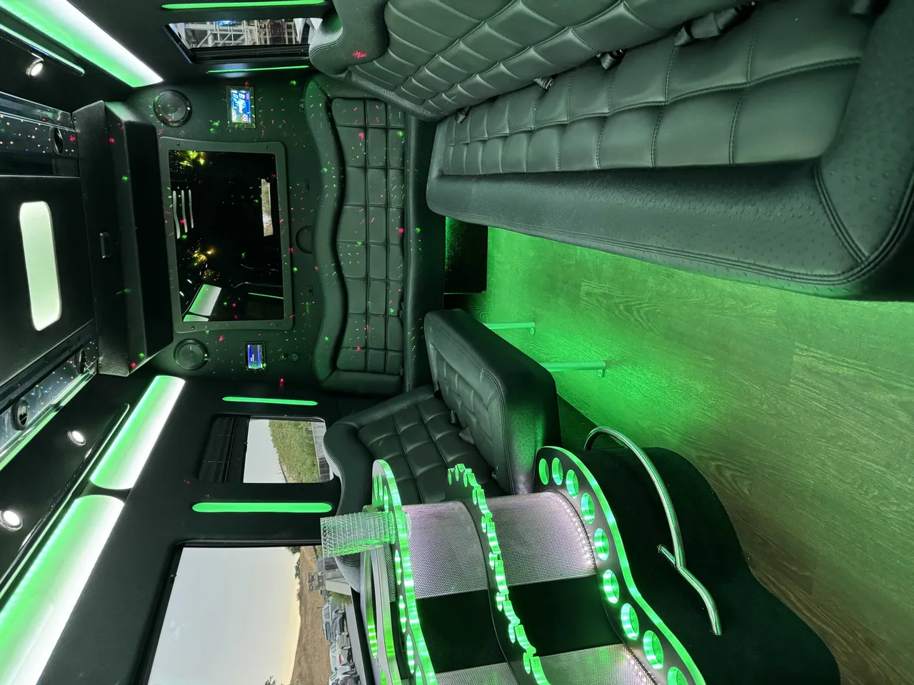 Mercedes-Benz Party Bus interior with perimeter lounge seating, LED accent lighting and wood-look flooring for party bus rental in Larkspur, CA