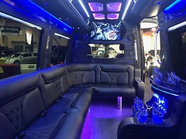 Mercedes Party Bus interior with sofa-style seating, LED accent lighting and LED ceiling lighting for party bus rental in Birds Landing, CA