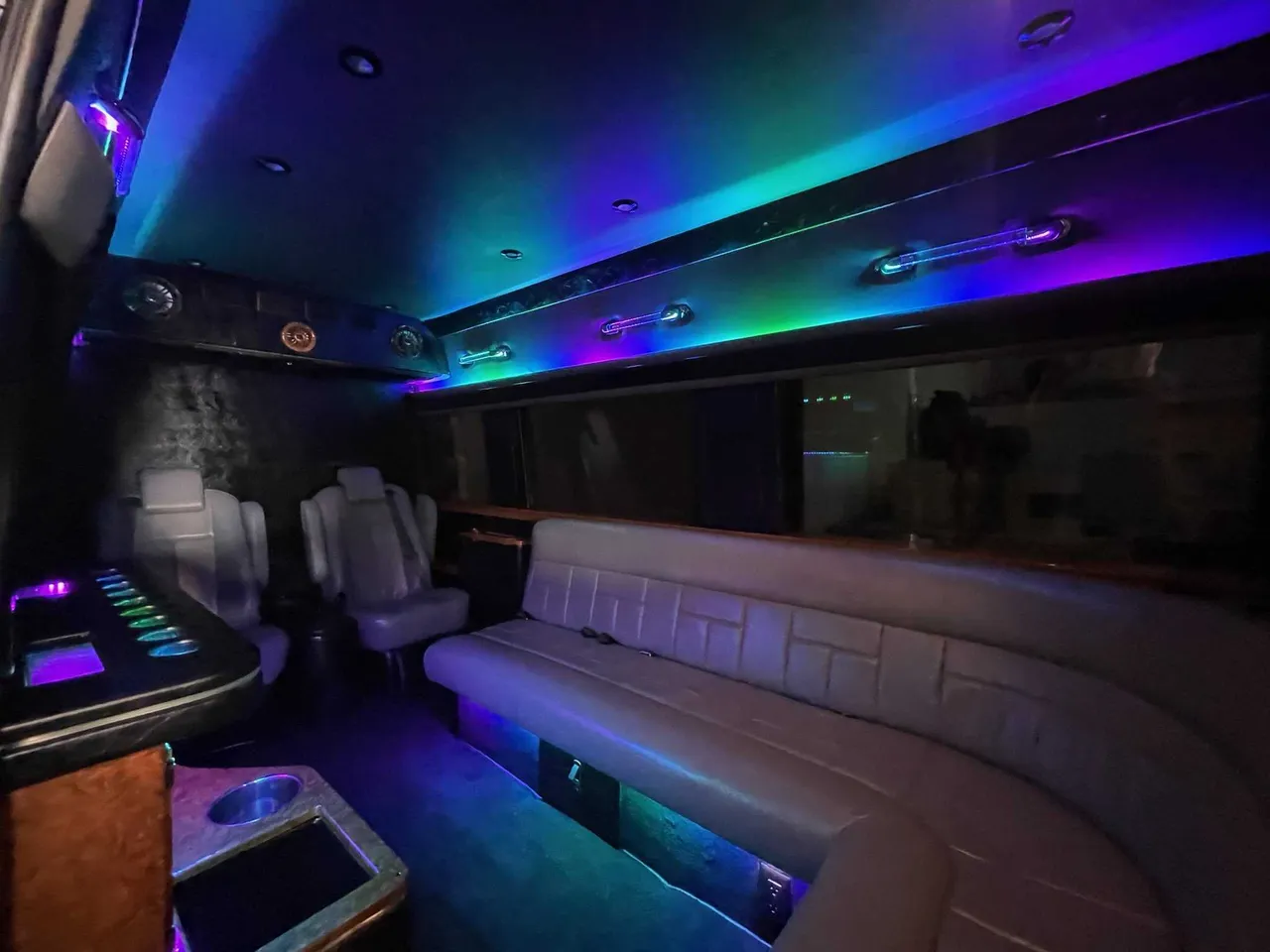 Mercedes Sprinter Limo interior with sofa-style seating, captain's chairs and LED accent lighting, photo 2 for party bus rental in Columbus County, NC