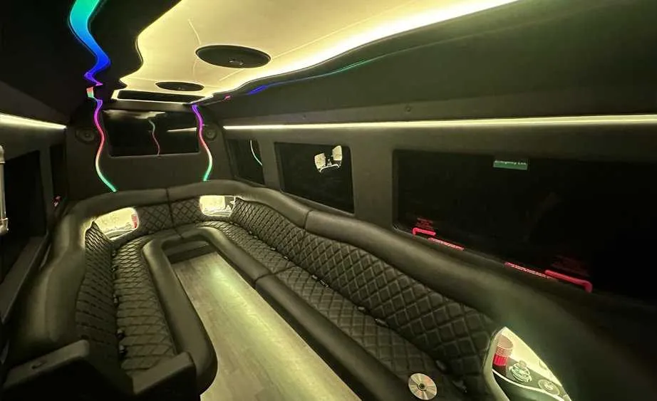 Mercedes Sprinter Limo interior with perimeter lounge seating, LED accent lighting and bar area for party bus rental in Birds Landing, CA