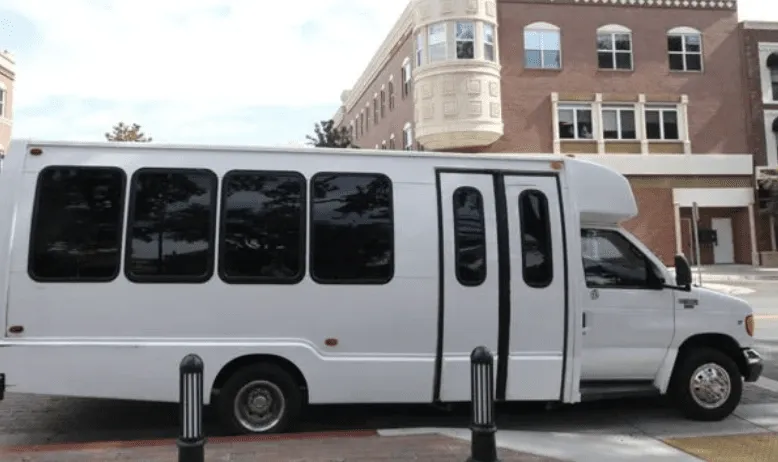 White 16 Passenger Party Bus exterior with tinted windows for party bus rental in Fresno County, CA