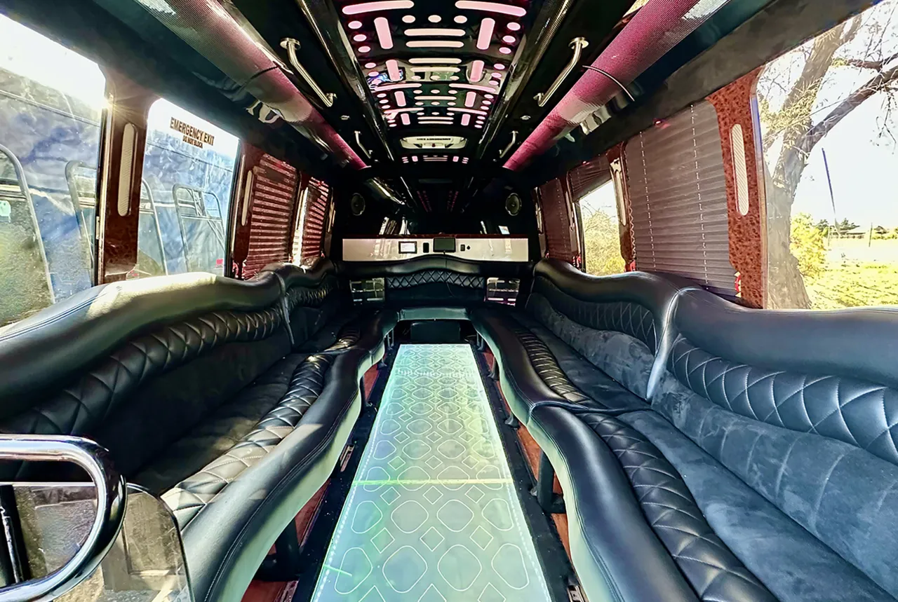 20 Passenger Party Bus interior with perimeter lounge seating, window shades and LED ceiling lighting for party bus rental in Laramie County, WY