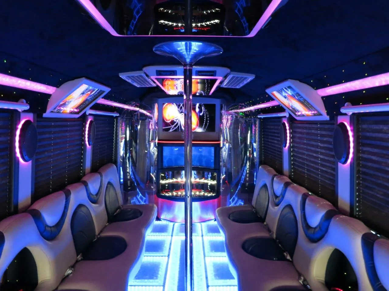 26 Passenger Party Bus interior with perimeter lounge seating, window shades and LED accent lighting for party bus rental in Long Barn, CA