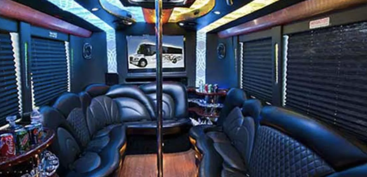 24 Passenger Party Bus interior with perimeter lounge seating, sofa-style seating and window shades for party bus rental in Mentone, CA
