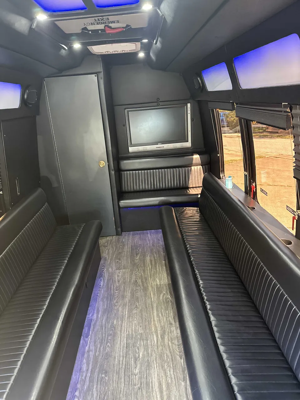 Small party bus interior with perimeter lounge seating, LED accent lighting and LED ceiling lighting for party bus rental in Union County, PA